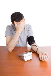 man testing his blood pressure with a home kit