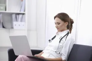 female nurse sitting chair using latop