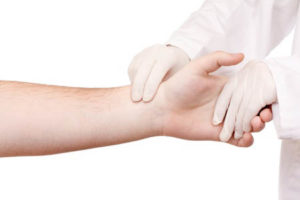 Nurse wearing gloves i in physical contact with patient in isolation.