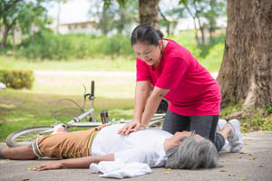 Wife performing hands-only CPR on her husband