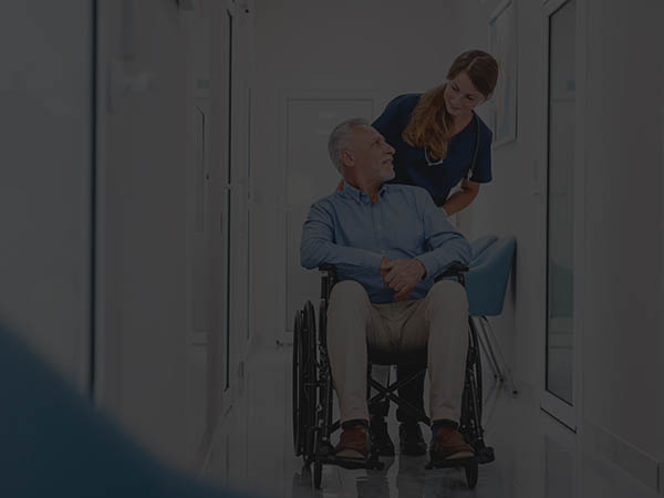 nurse-pushing-an-old-man-in-a-wheelchair