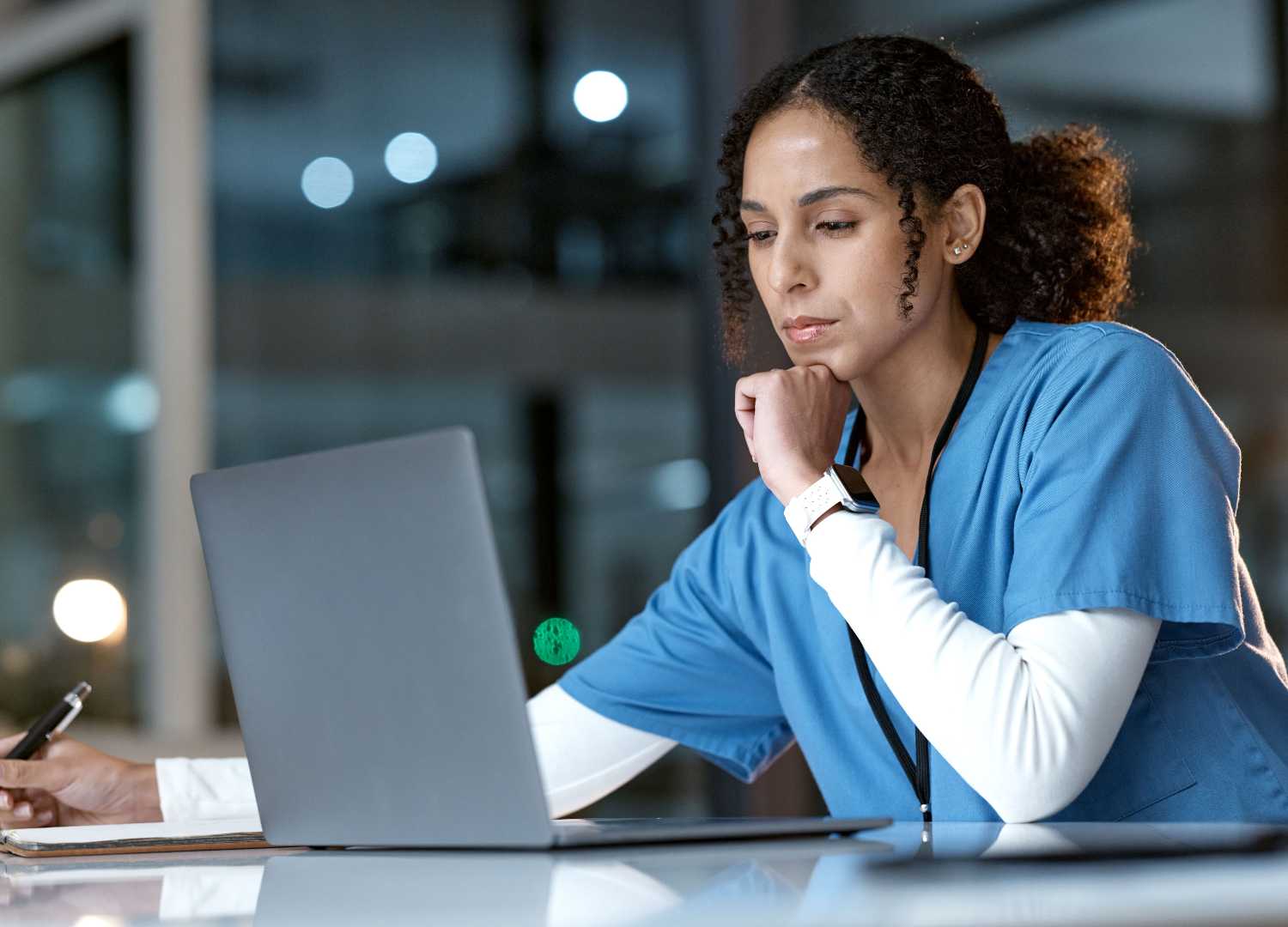 Female nurse working on a laptop during a night shift.