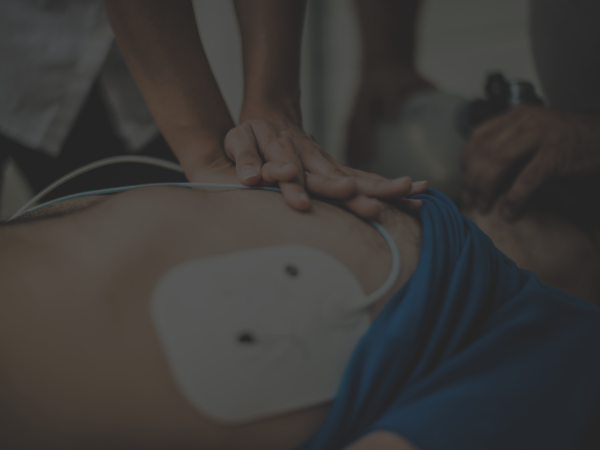 Performing CPR on a patient with an AED pad.