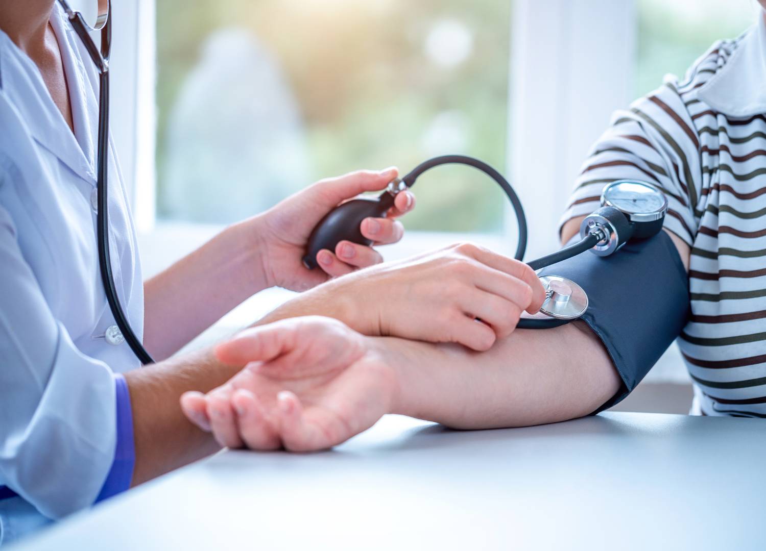 Health care professional measuring blood pressure of a patient.