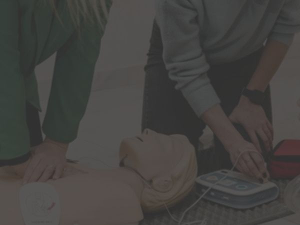 group of people discussing bls with the use of manikin and aed featured