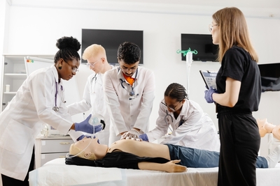 group of medical students performing acls on a mannequin