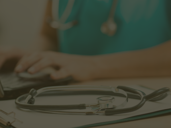 woman working on a laptop with stethoscope besider her f